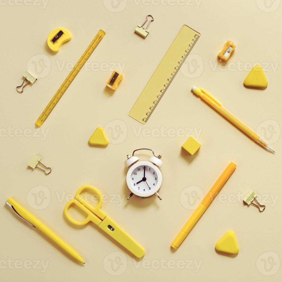 Alarm clock shows 8 oclock in morning, time to go to school concept. Flat lay with stationary school supplies photo