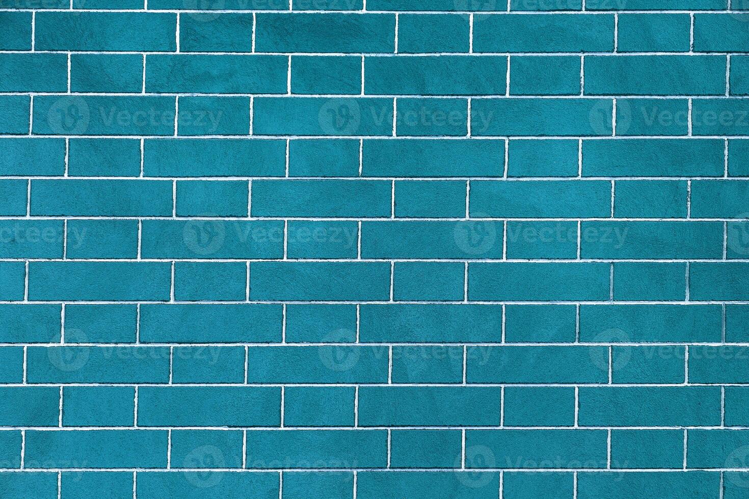 Brick wall is bright blue colored, texture of stone blocks, background of bricks. photo