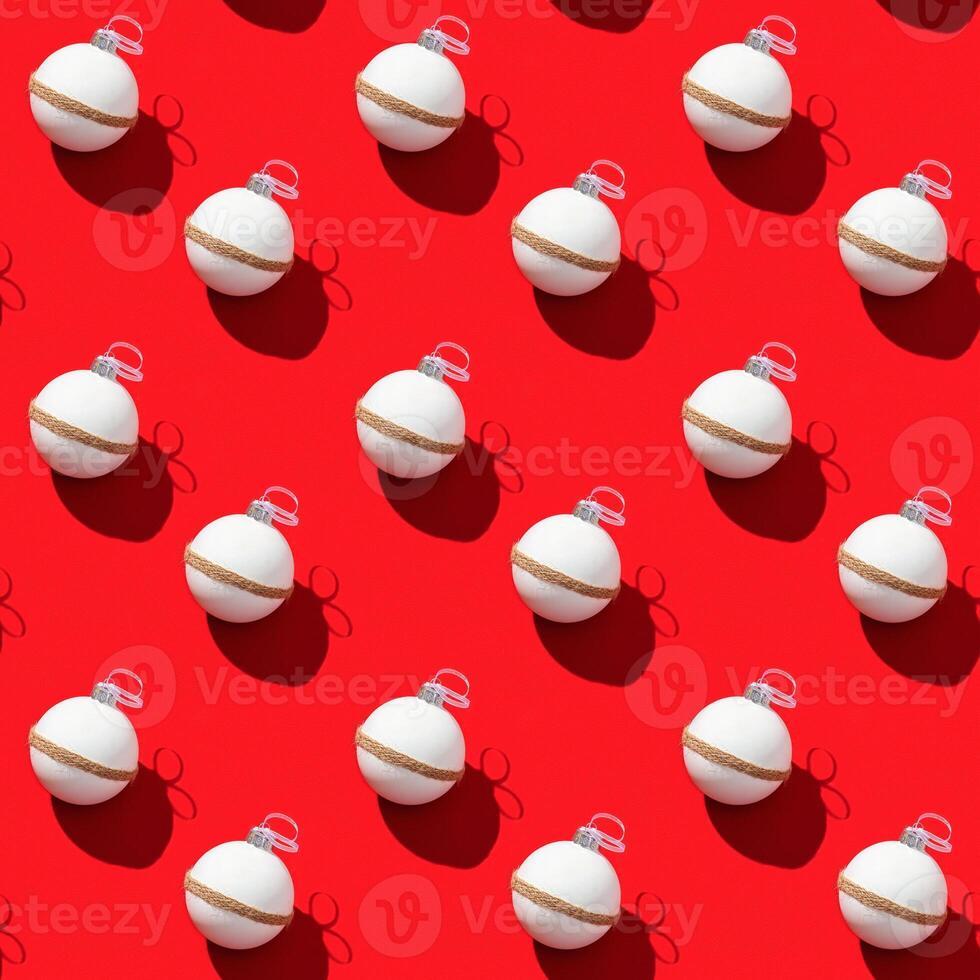 Christmas geometric pattern with white balls on red paper. Beautiful New Year toys with dark shadows. photo