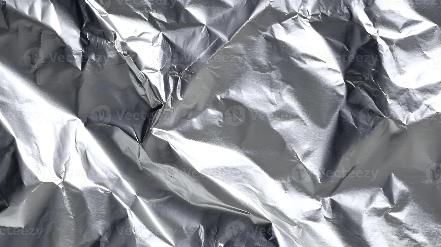 Metallic brilliance unfolds in a textured dance of light and shadow on crumpled foil surface texture photo