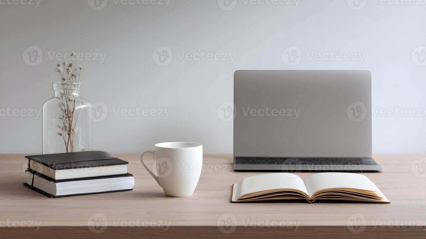 Serene workspace featuring a laptop, open notebook, coffee mug, books, and a vase with dry flowers photo