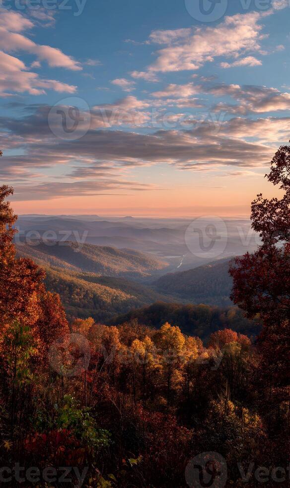 Autumnal panoramic vista showcases rolling mountains framed by colorful trees under a vibrant skyscape at sunset photo