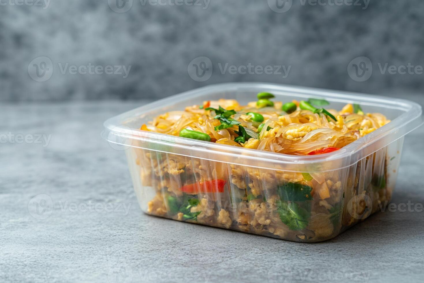 A plastic container filled with food on a gray background photo