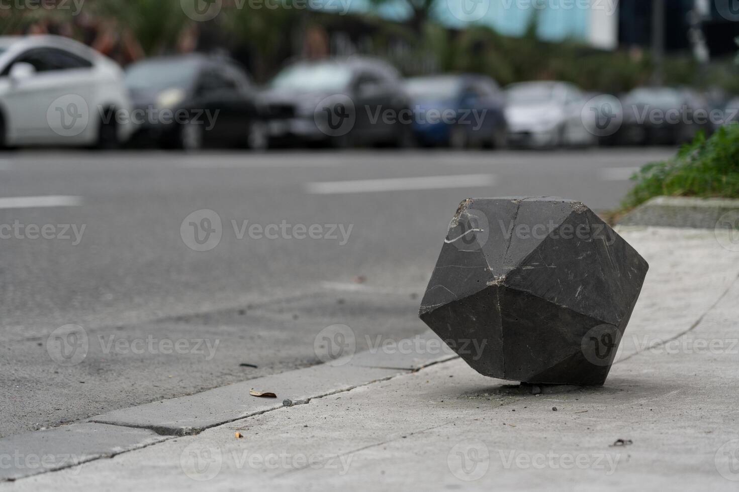 Concrete fence polygonal cube on the background of the road photo