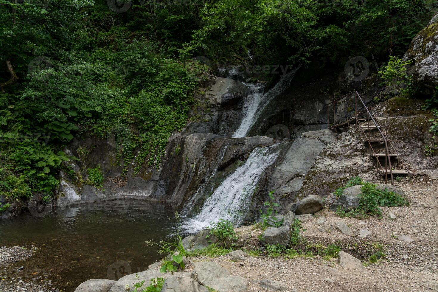 An observation deck near a small waterfall in the mountains of Georgia photo
