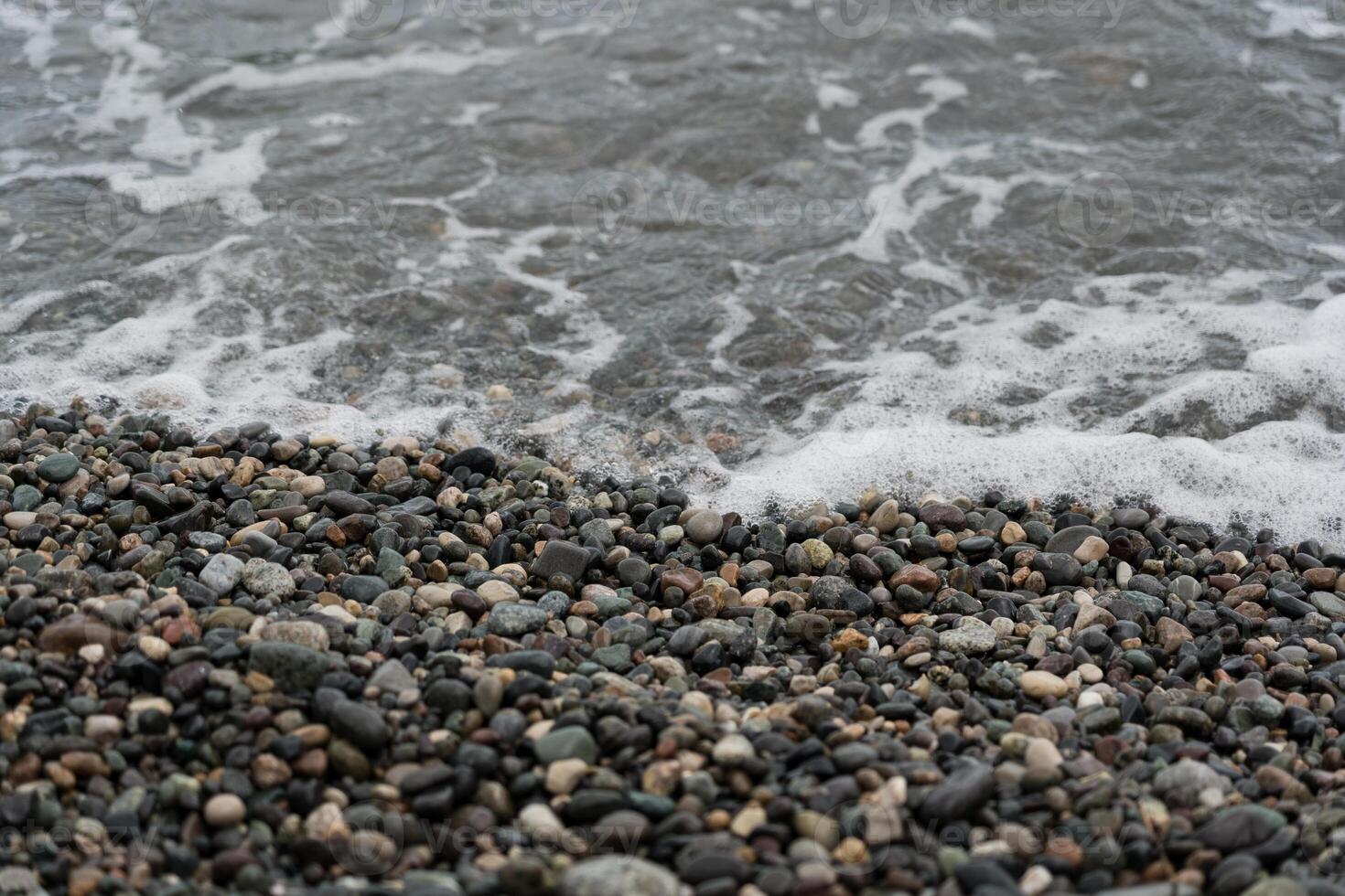 Foam from a receding wave on a stone beach in Batumi, photo