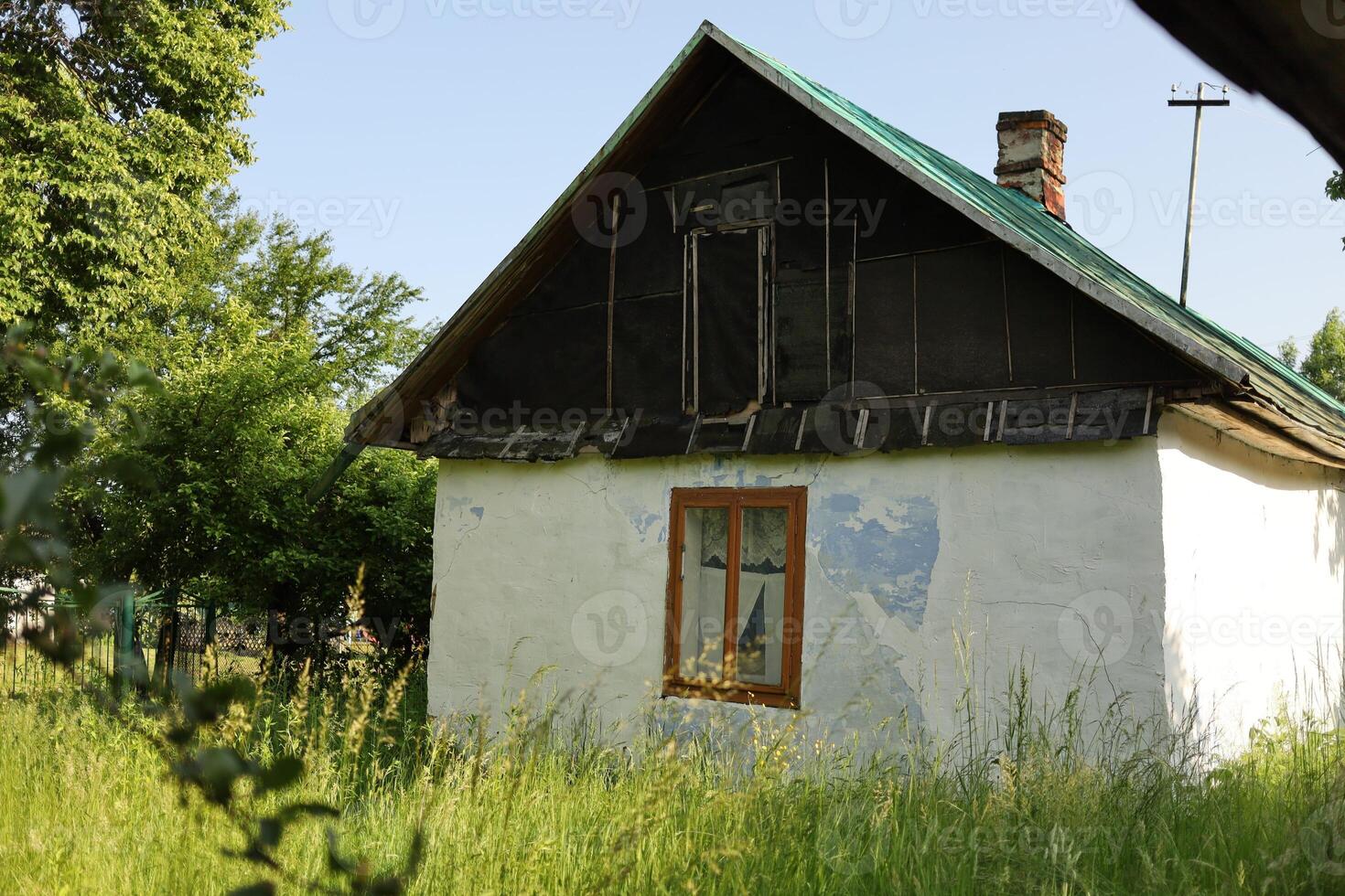 A small white house with a green roof photo