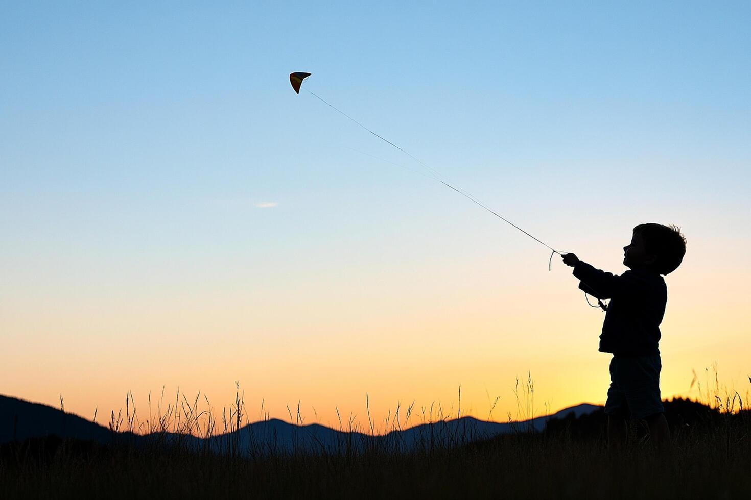 A boy flying a kite at sunset photo