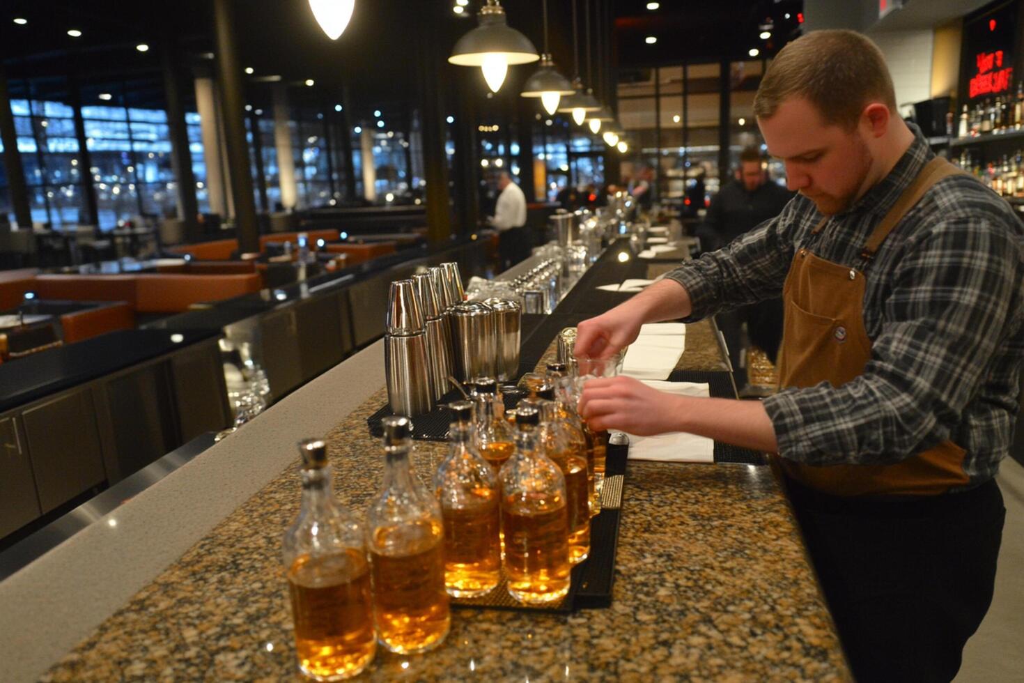A man in an apron is pouring liquor into bottles photo