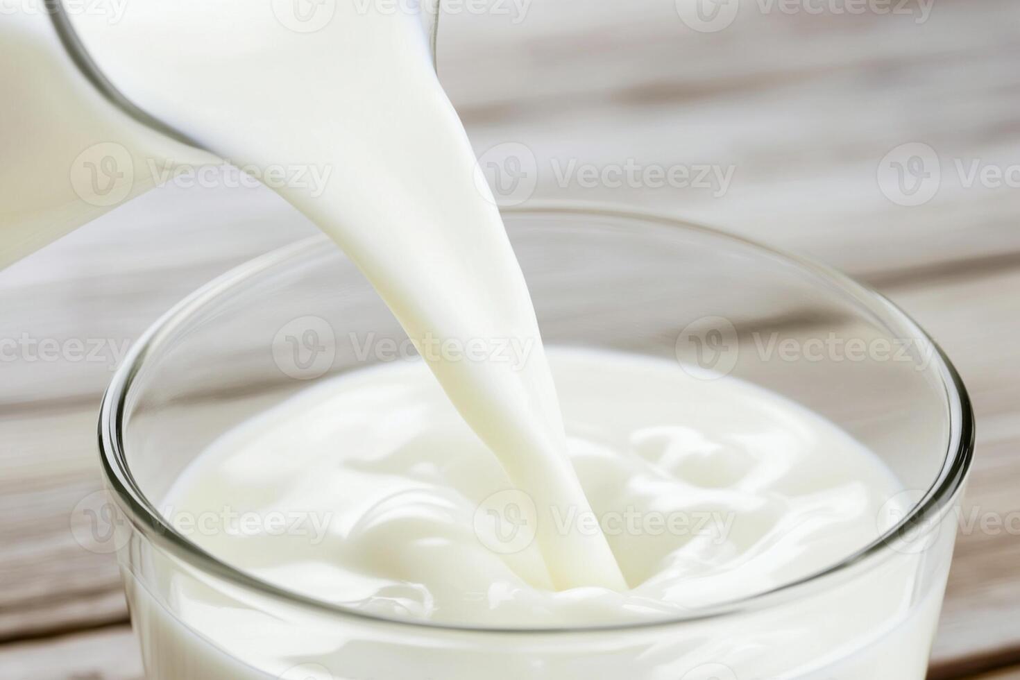 A glass of milk being poured into a glass photo