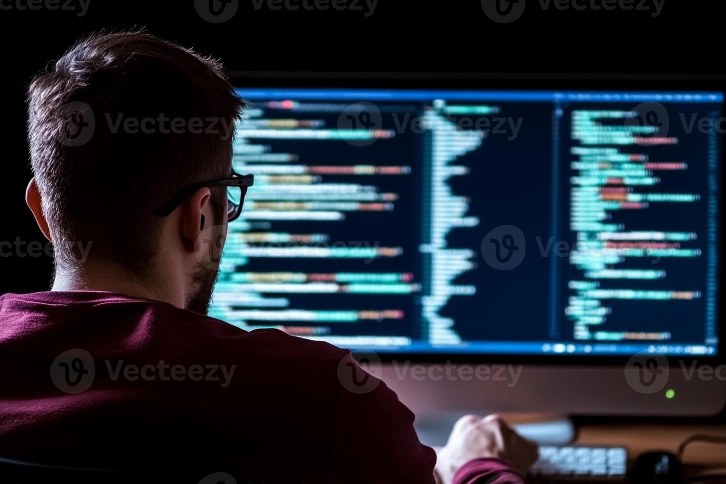 A man is sitting at a computer with a computer screen photo