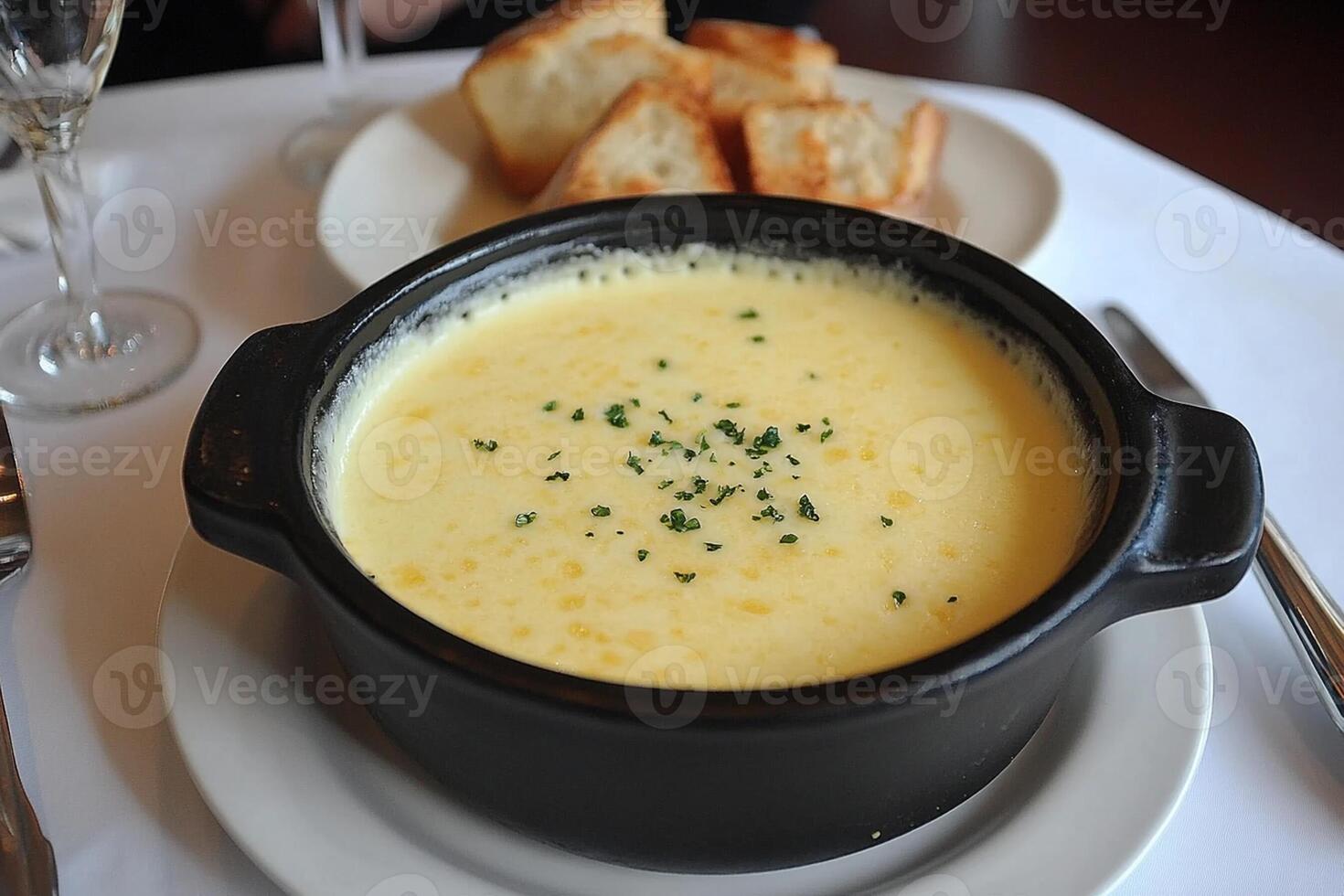 A bowl of soup with bread on a plate photo