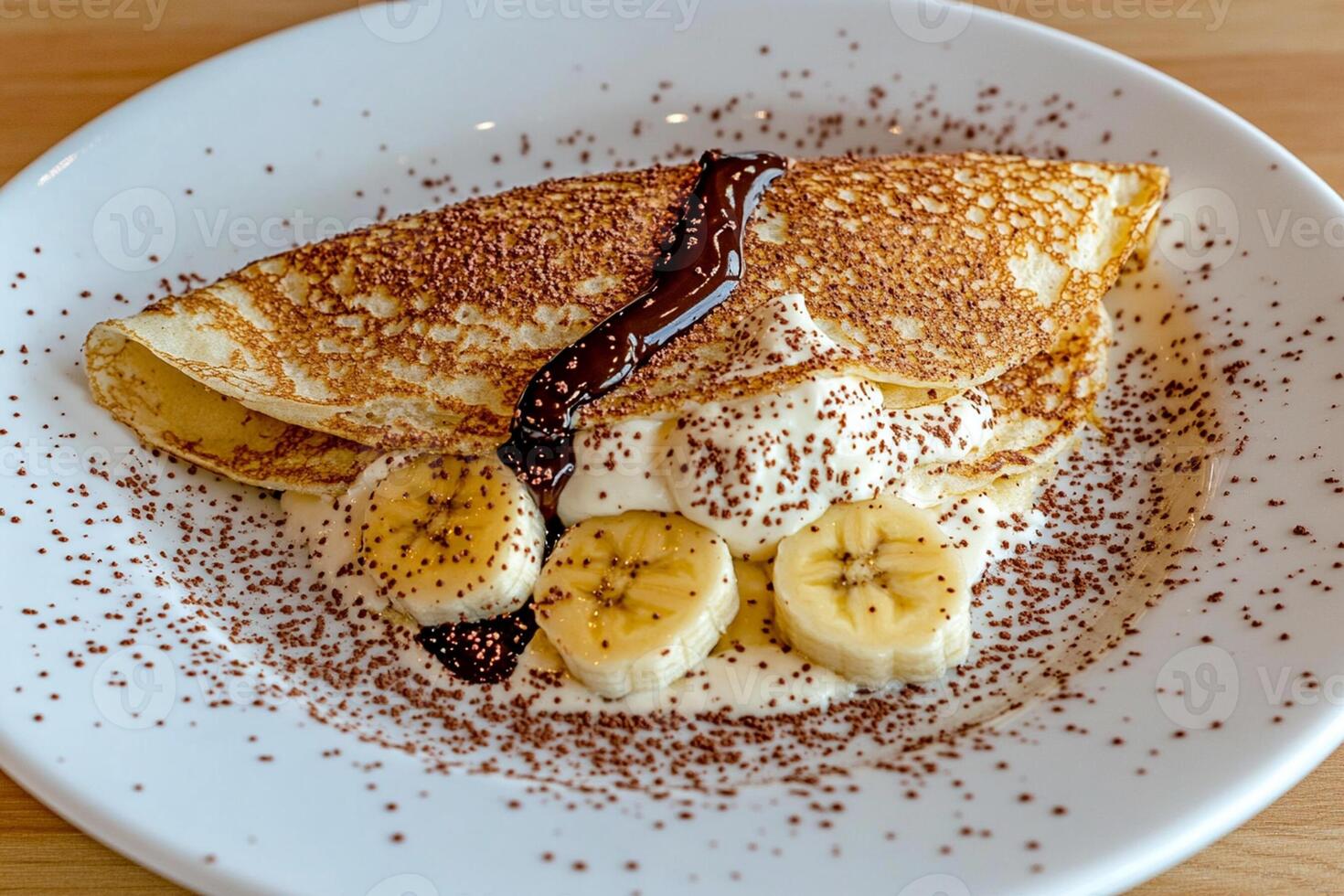 A plate of pancakes with bananas and chocolate sauce photo