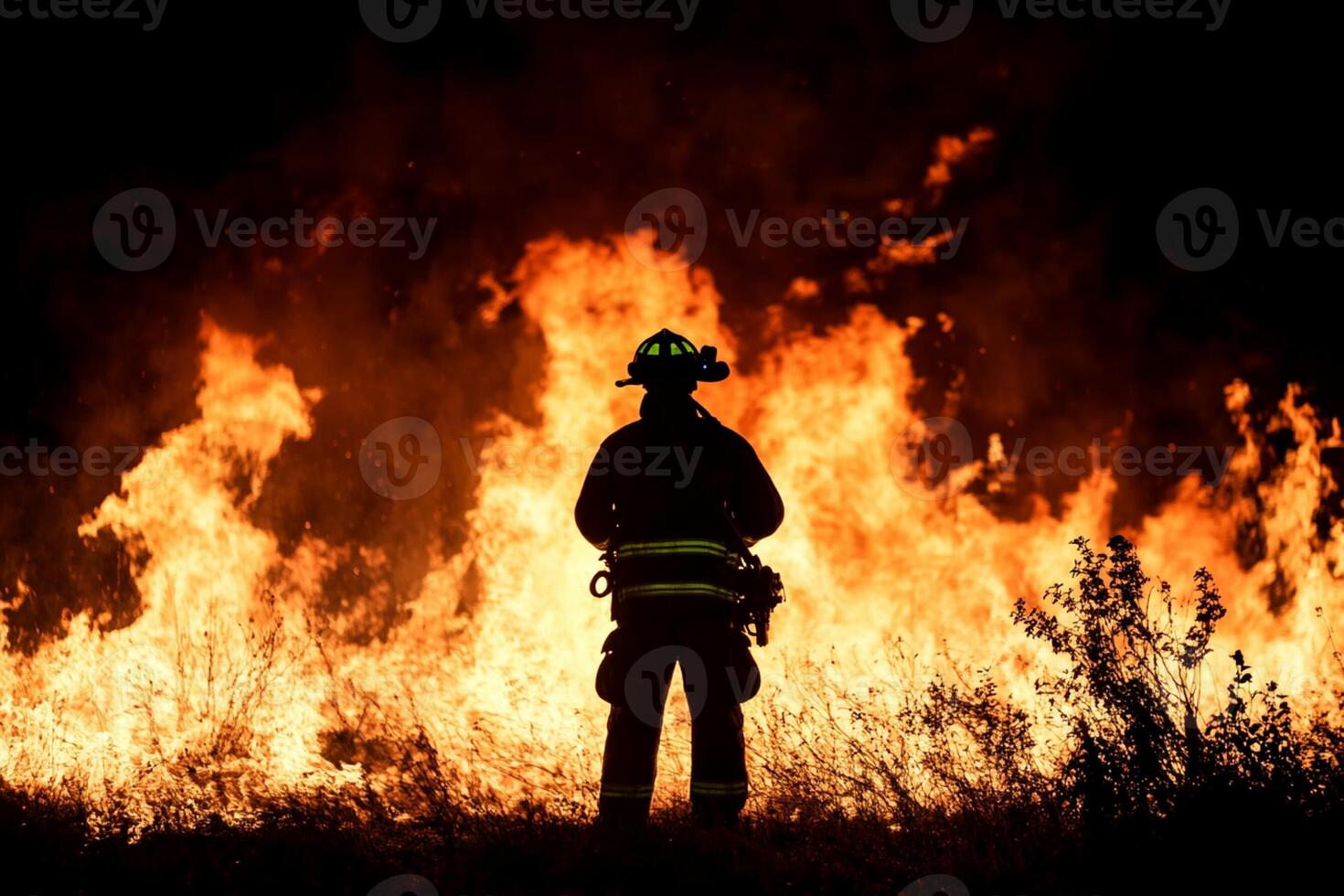 A firefighter standing in front of a fire photo