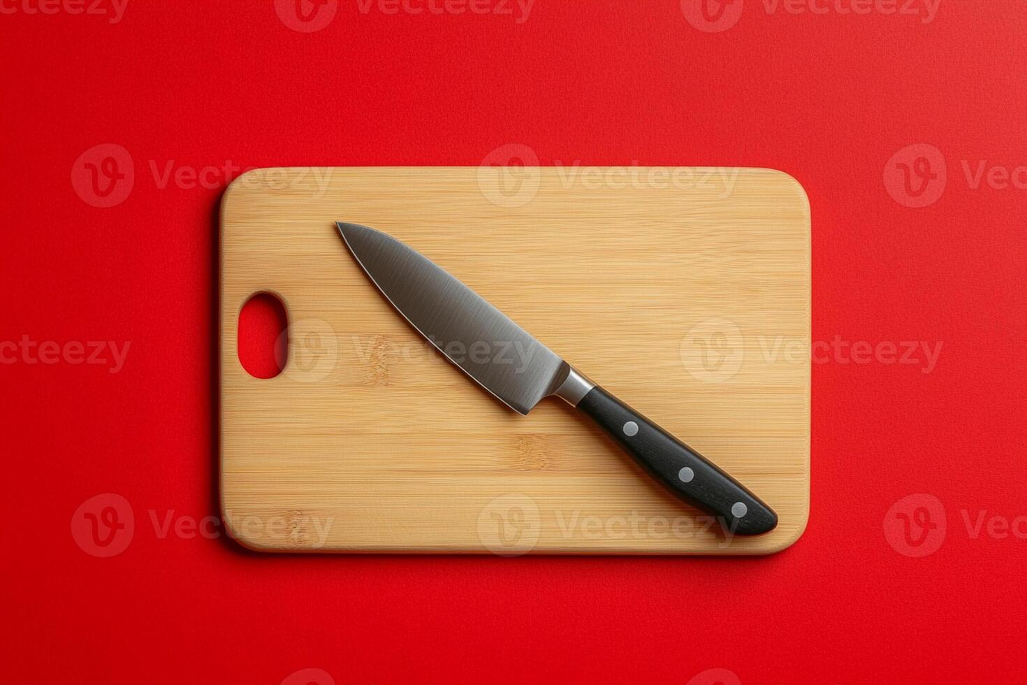 A knife on a cutting board on a red background photo