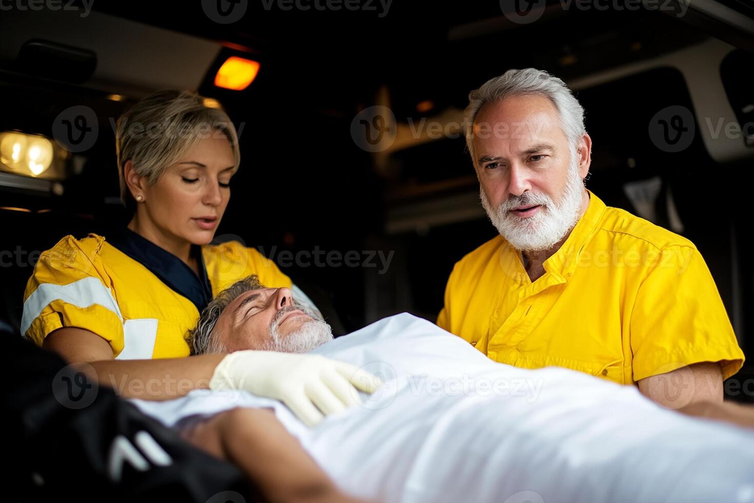 A man in a yellow uniform is being helped by an ambulance worker photo