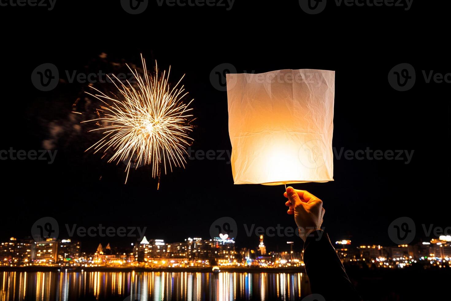 A person holding a paper lantern over a city at night photo