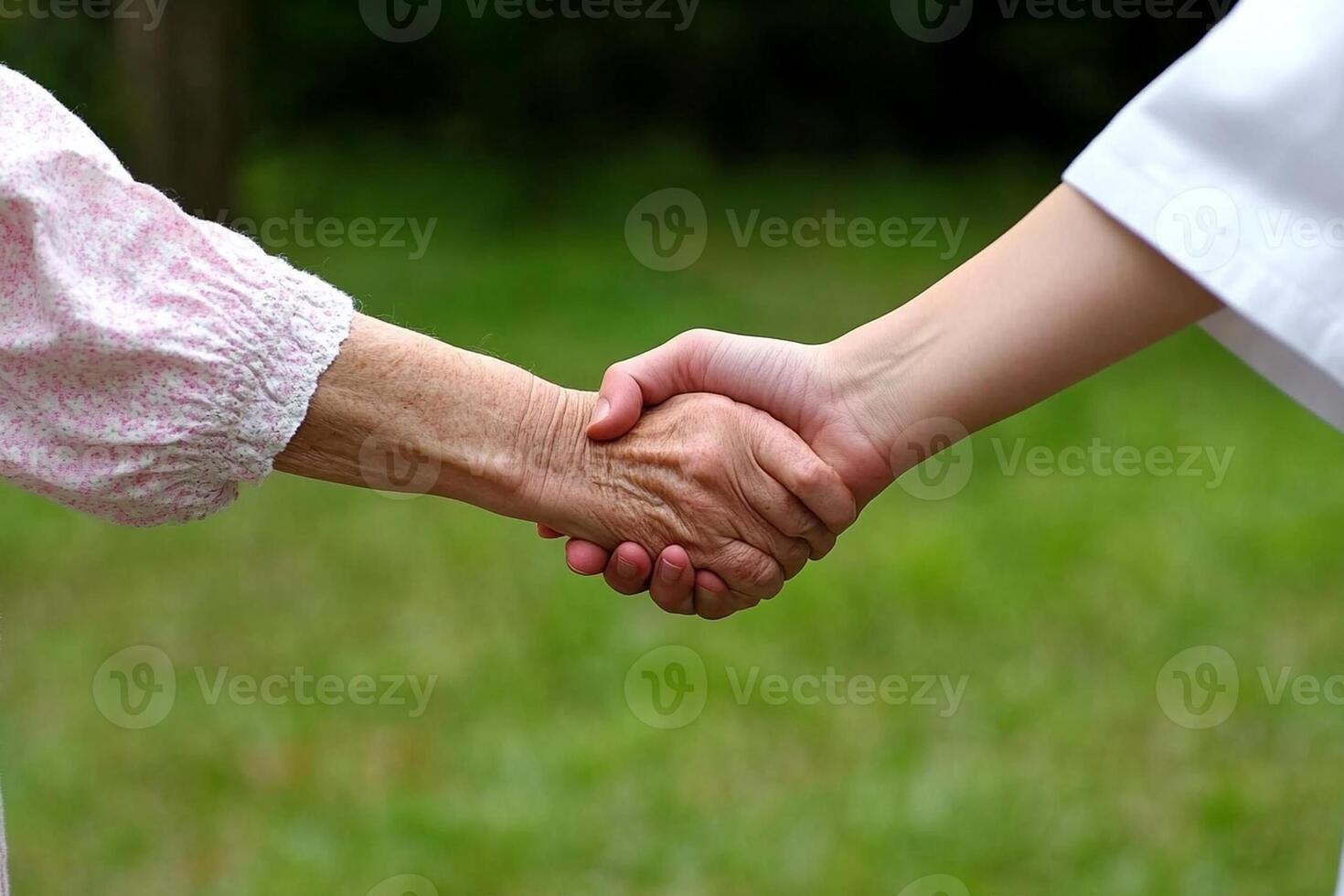 A nurse holding the hand of an elderly woman photo