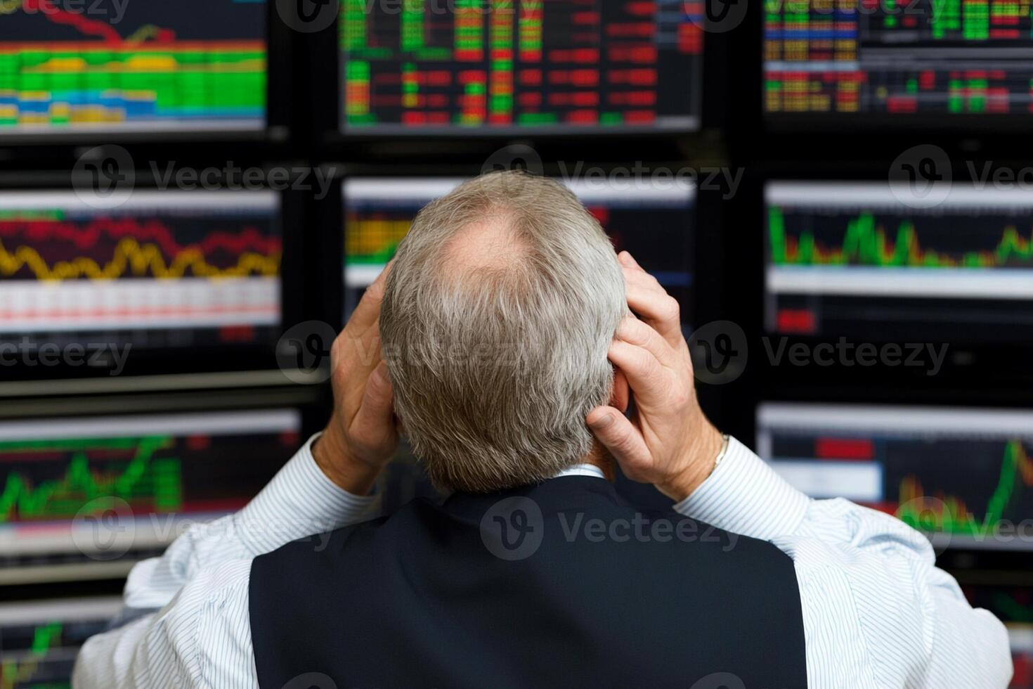 A man is looking at multiple screens of stock market data photo
