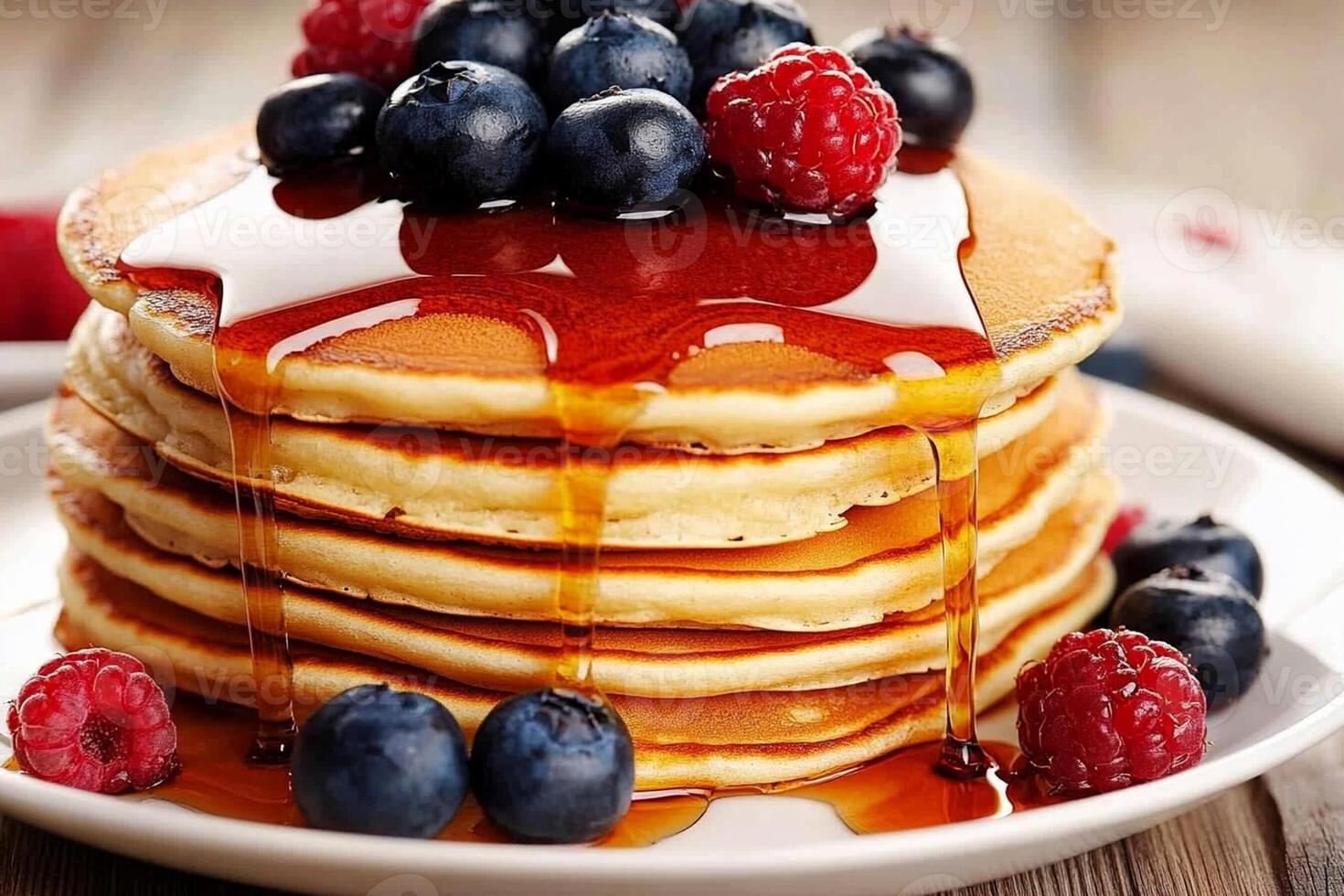 A stack of pancakes with berries and syrup photo