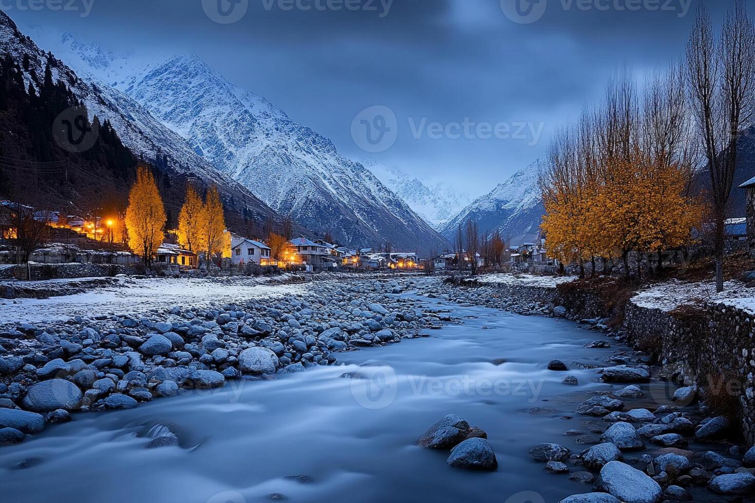 A river flows through a mountain town at night photo