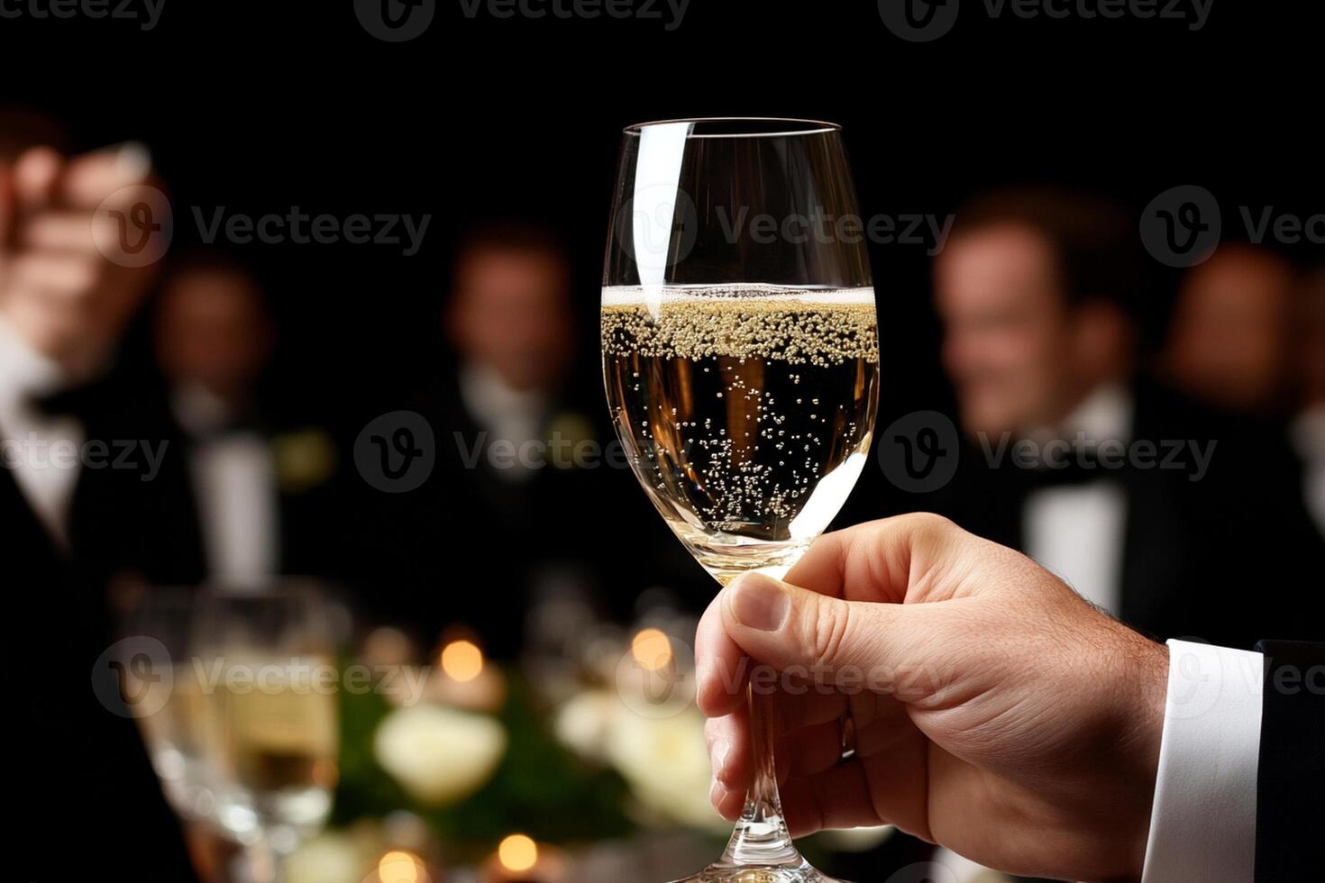 A person holding a glass of champagne at a dinner party photo