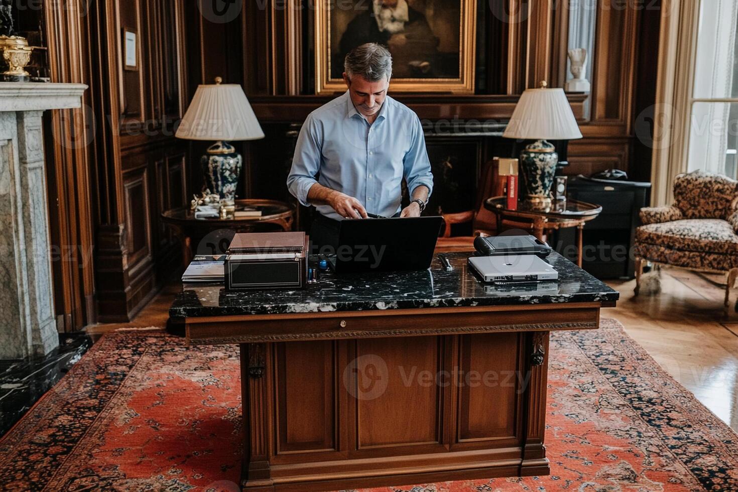 A man in a blue shirt is working on his laptop photo