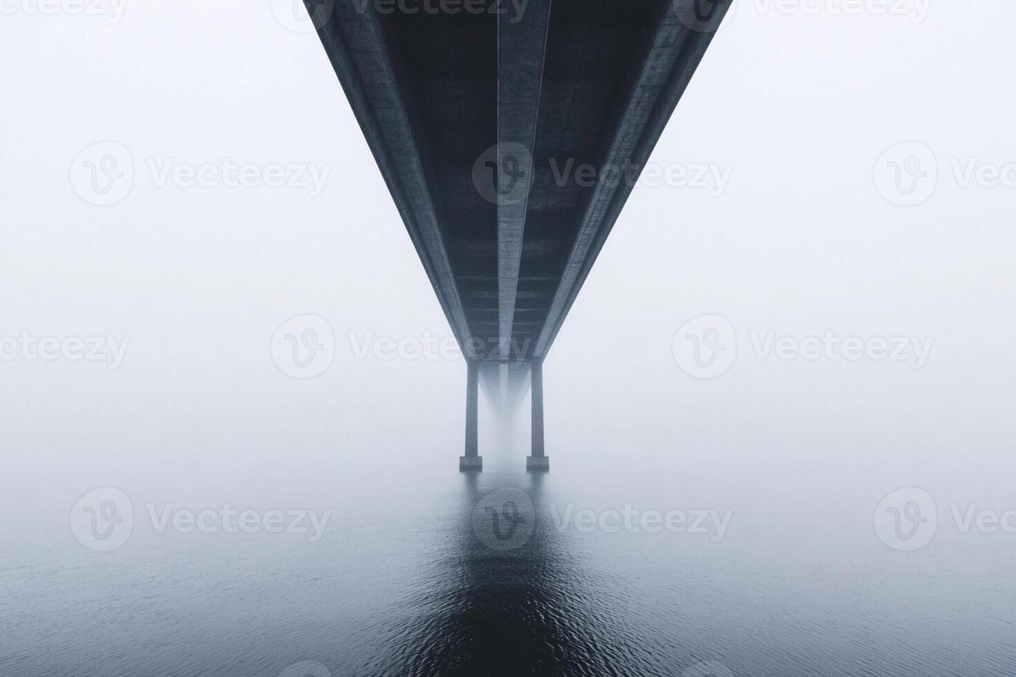 A bridge over water with a foggy sky photo