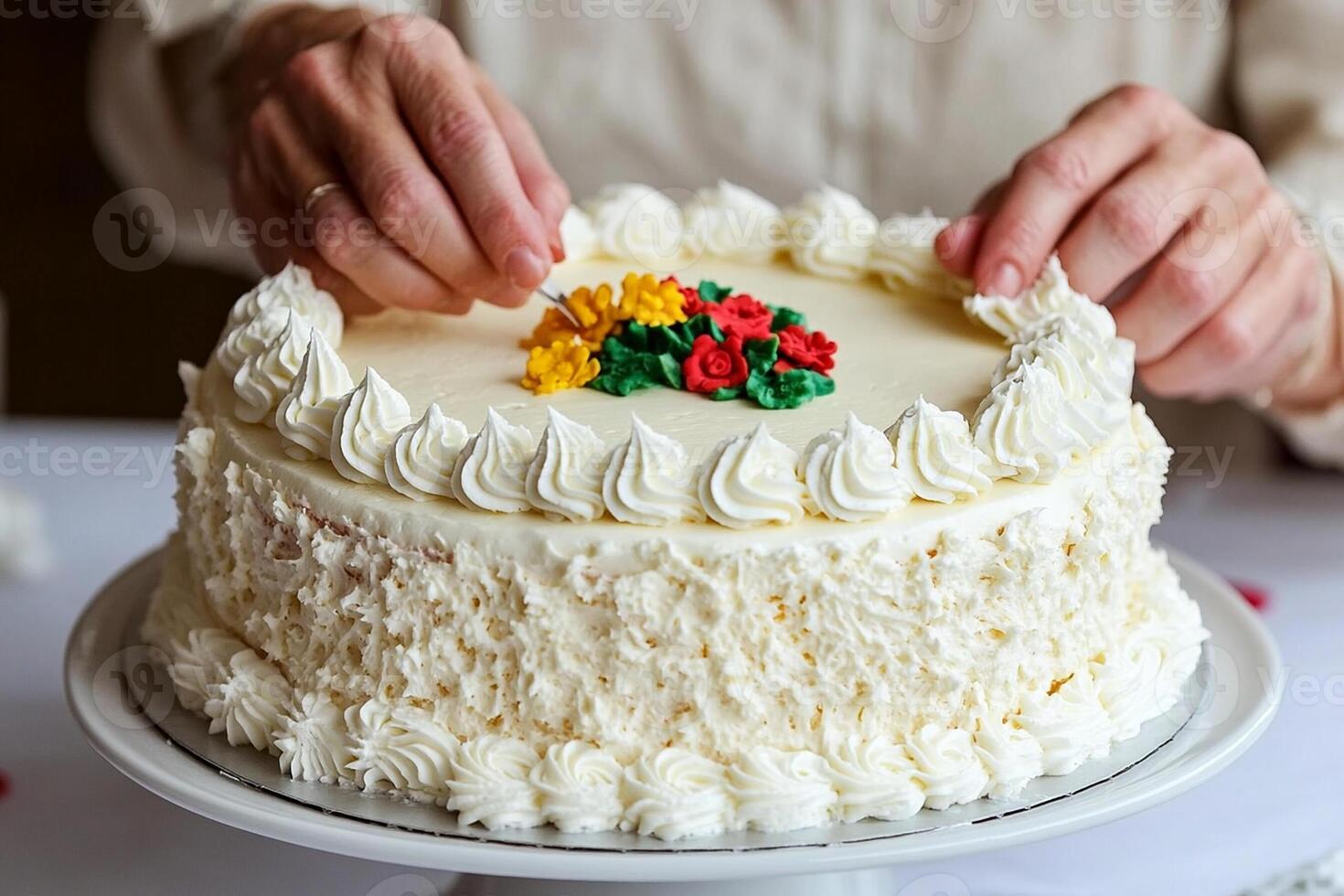 A person is cutting a cake with frosting photo