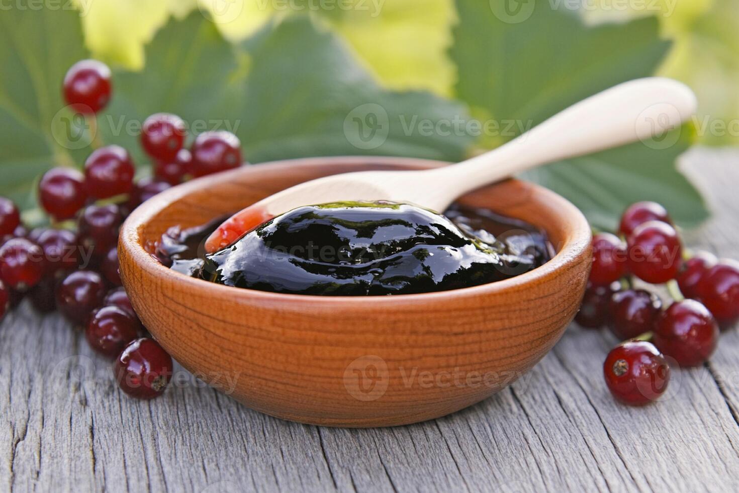 A bowl of black jelly with a spoon on top of a table photo