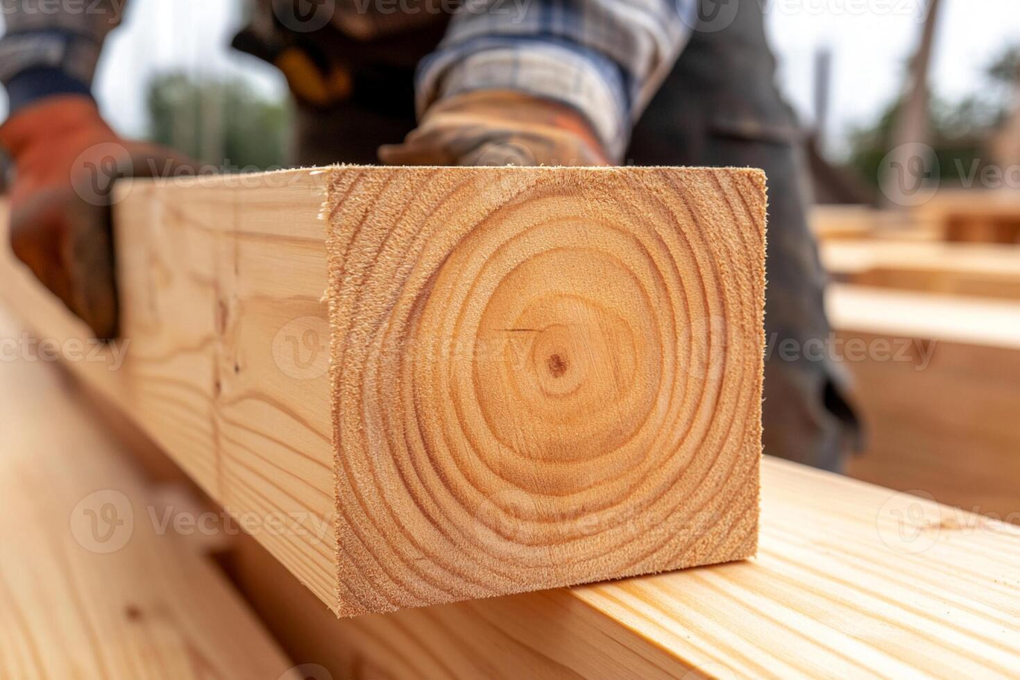 A man is holding a piece of wood on a construction site photo