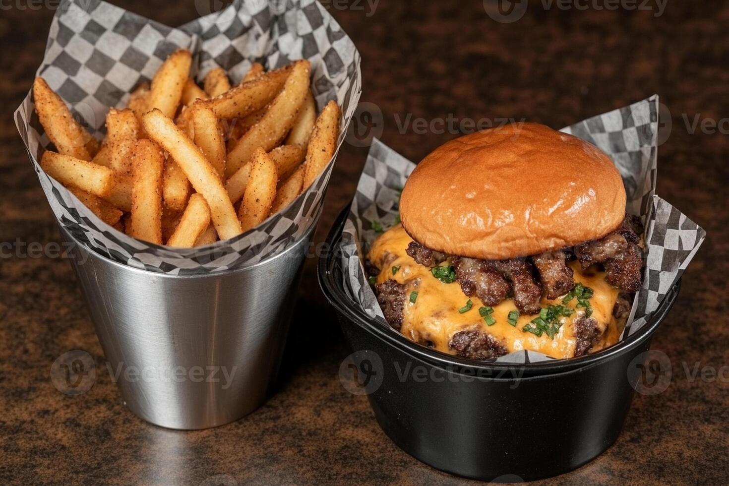 A cheeseburger and fries in a black cup photo