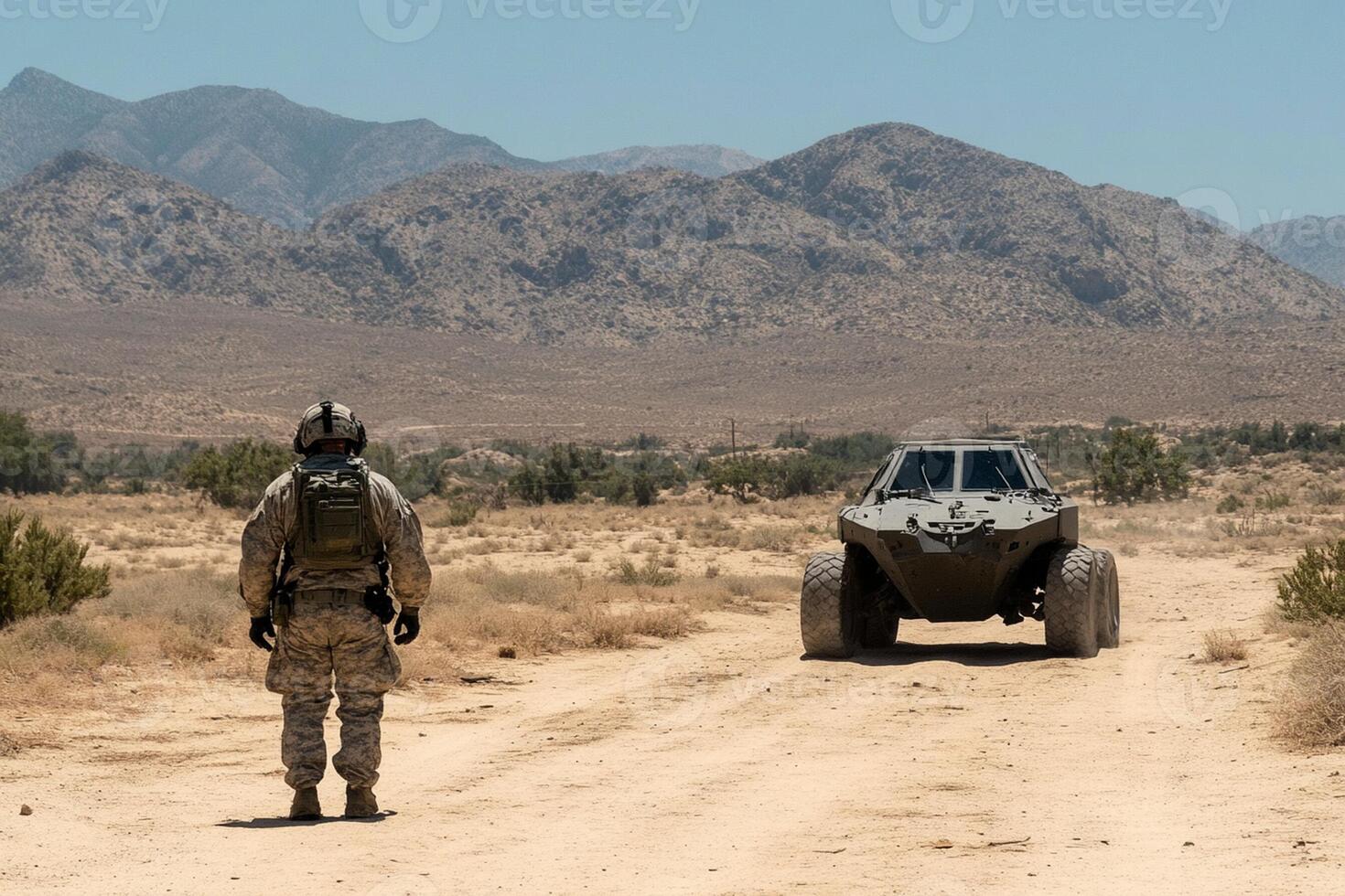 A soldier standing in the middle of a desert road with a vehicle photo