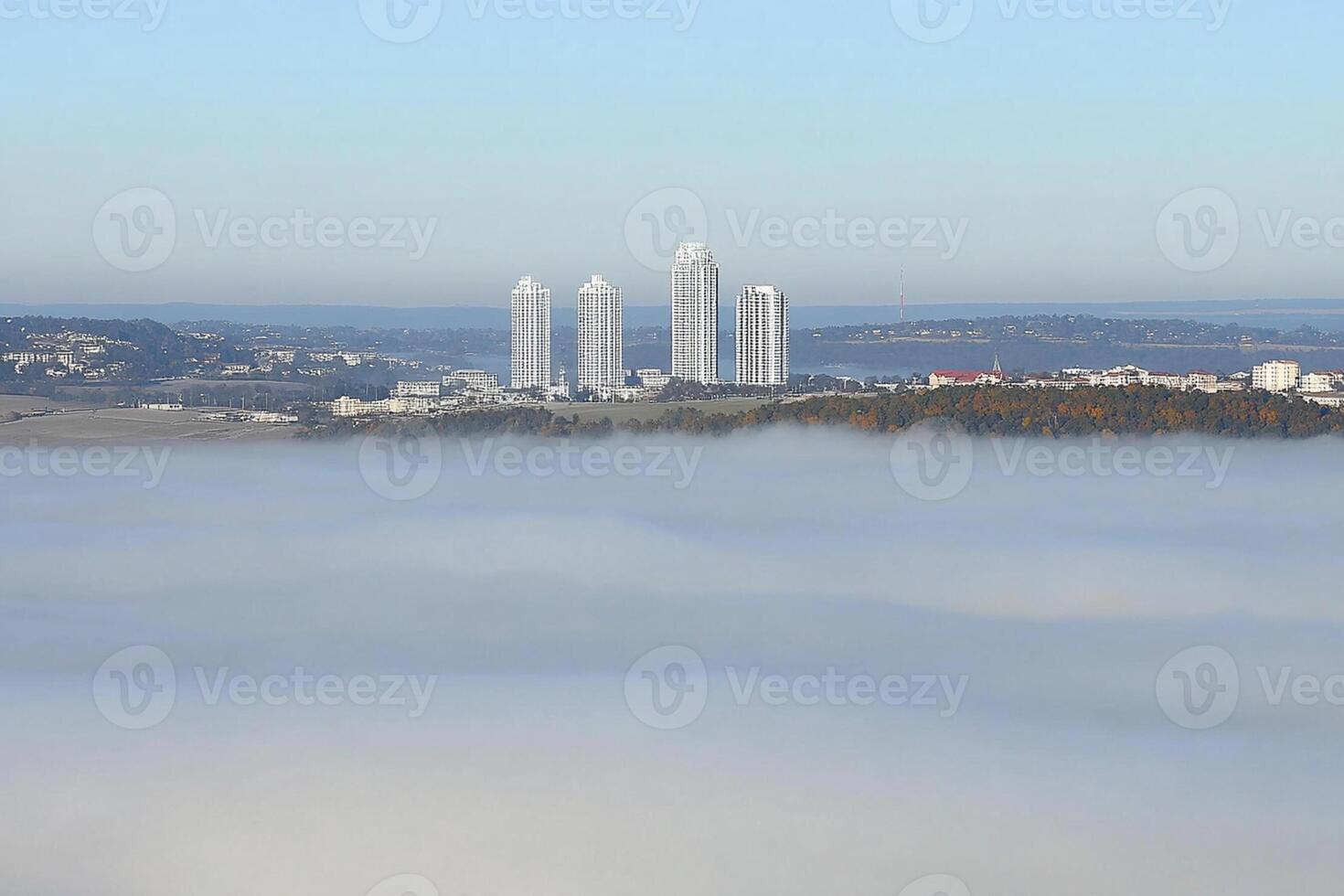 A city is seen in the fog on a hill photo