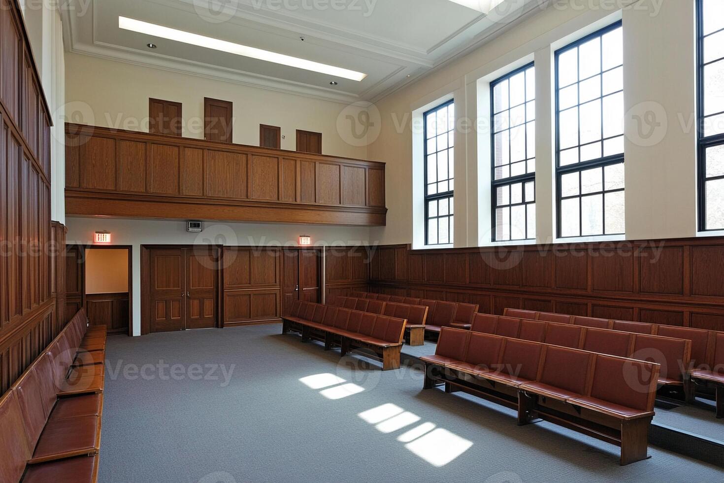 A large empty room with wooden benches and windows photo