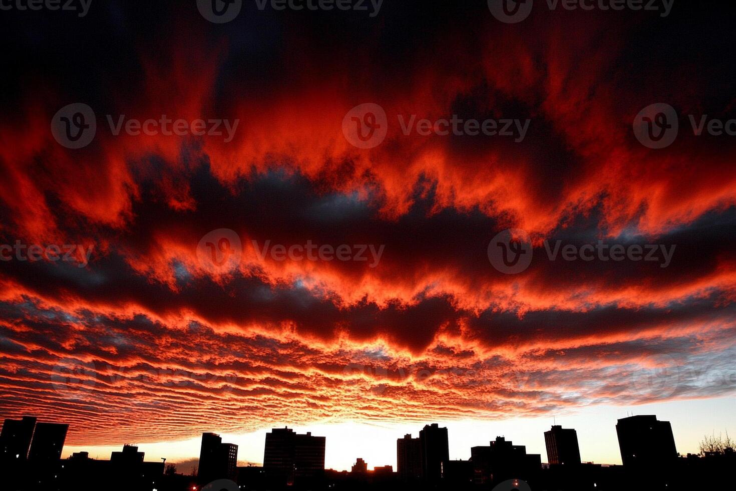 A red sky with clouds over a city photo