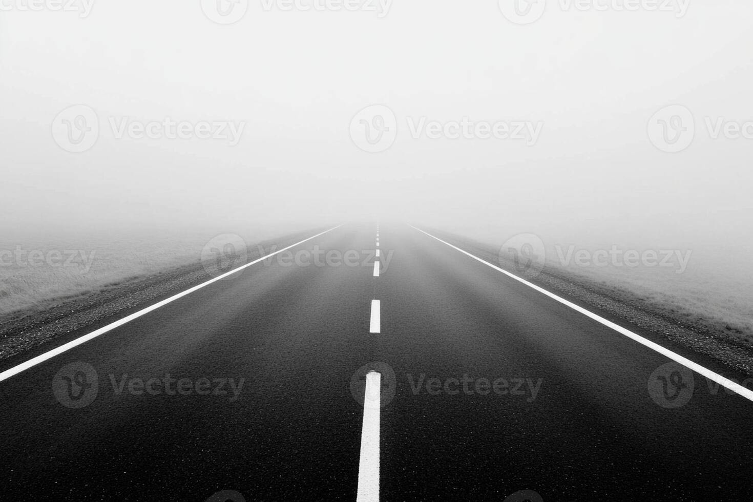 Black and white photo of empty road in fog
