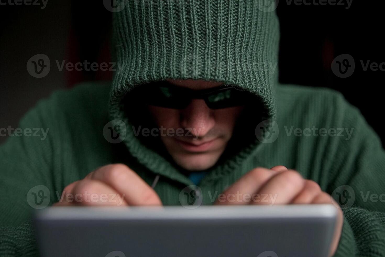 A man in a hoodie is using a tablet photo