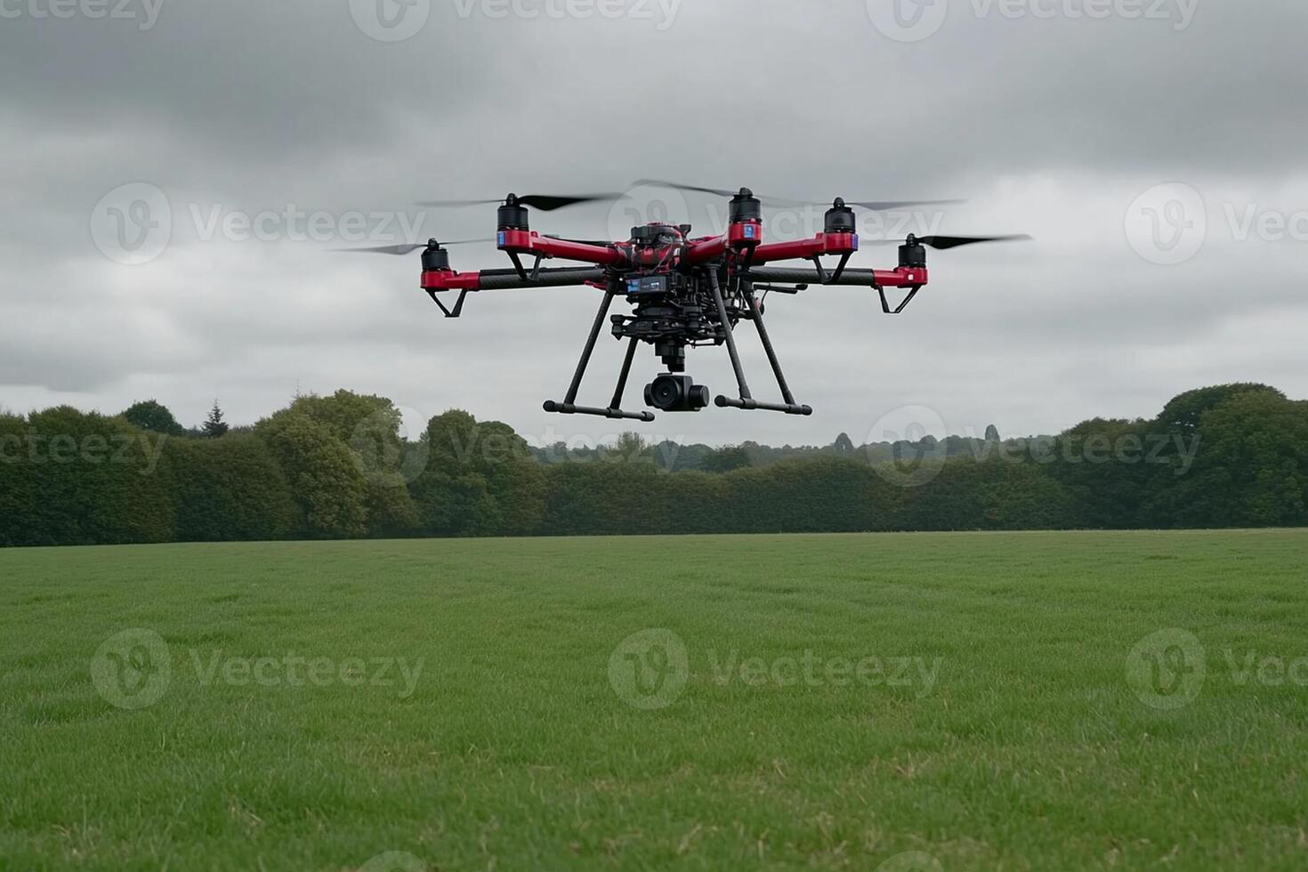 A large black and red drone flying in a field photo