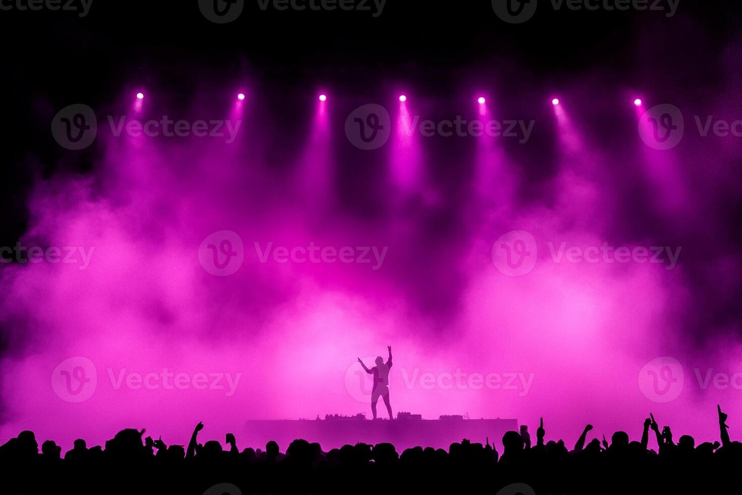 A person standing on stage with purple lights photo