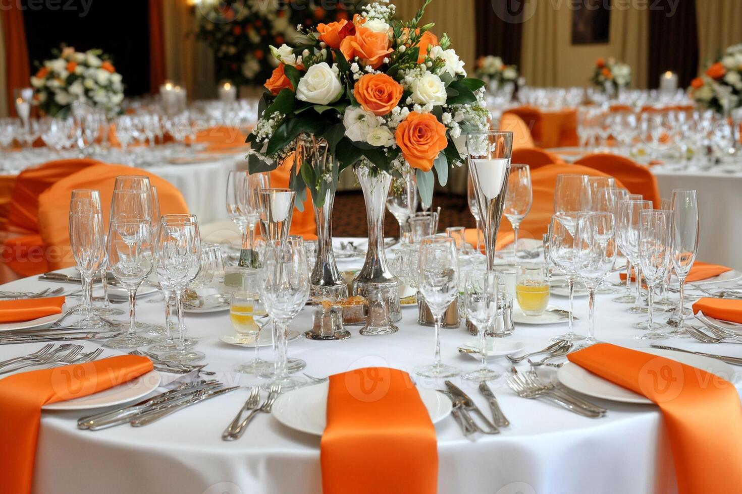 A table with orange and white tablecloths and silverware photo