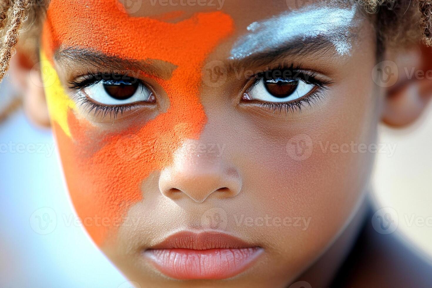 A young boy with orange paint on his face photo