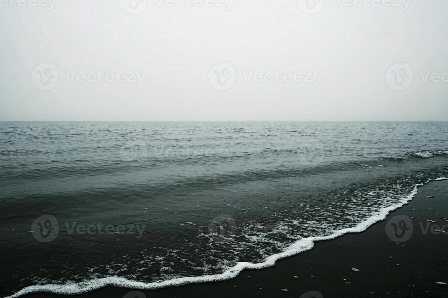 A black and white photo of a beach with waves