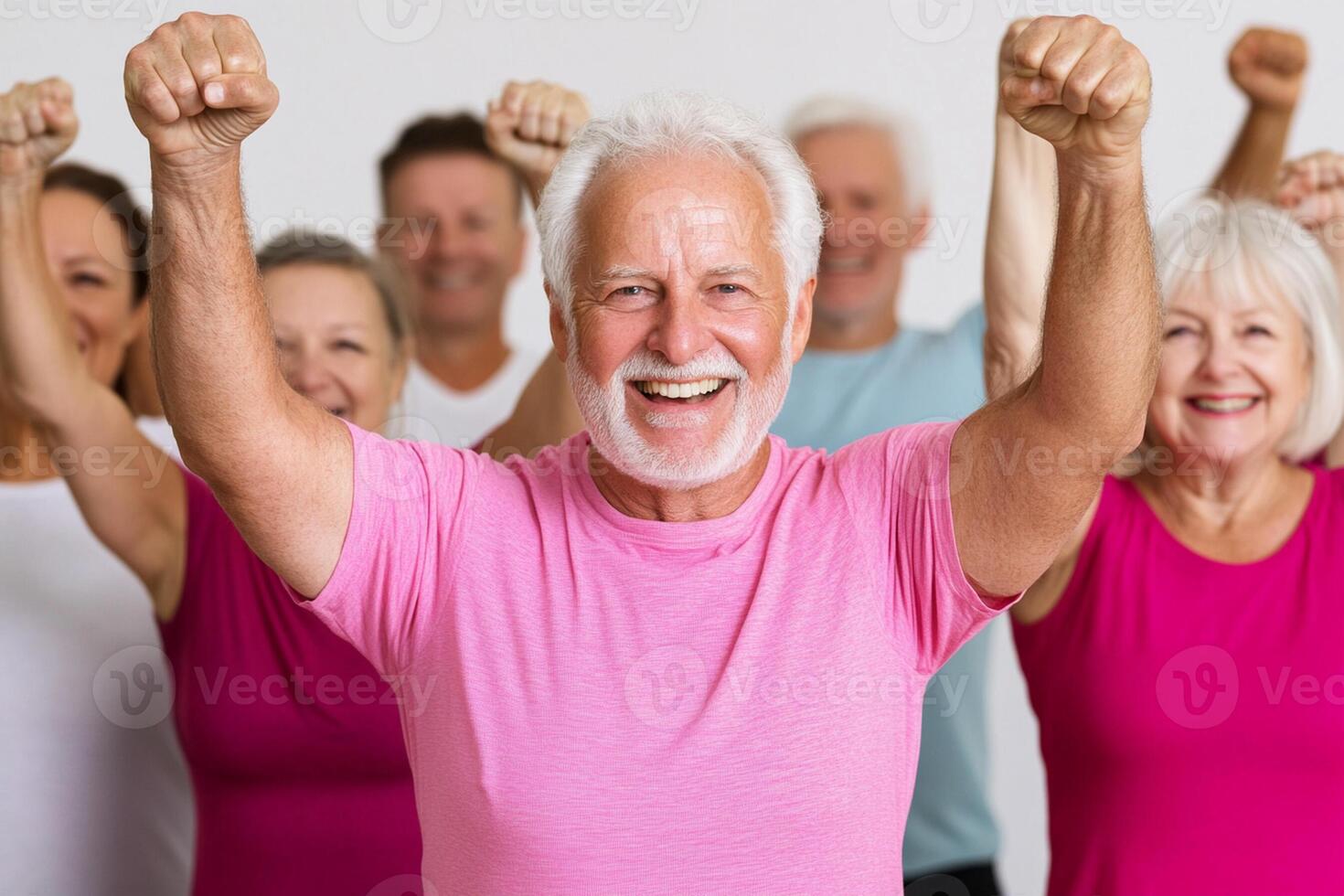 A group of people in pink shirts and white shirts are raising their arms photo