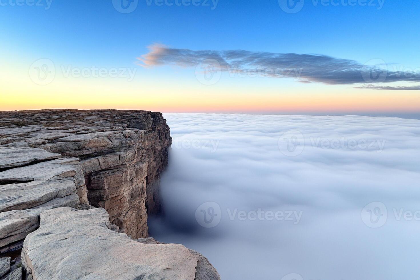 A cliff with a view of the clouds above photo