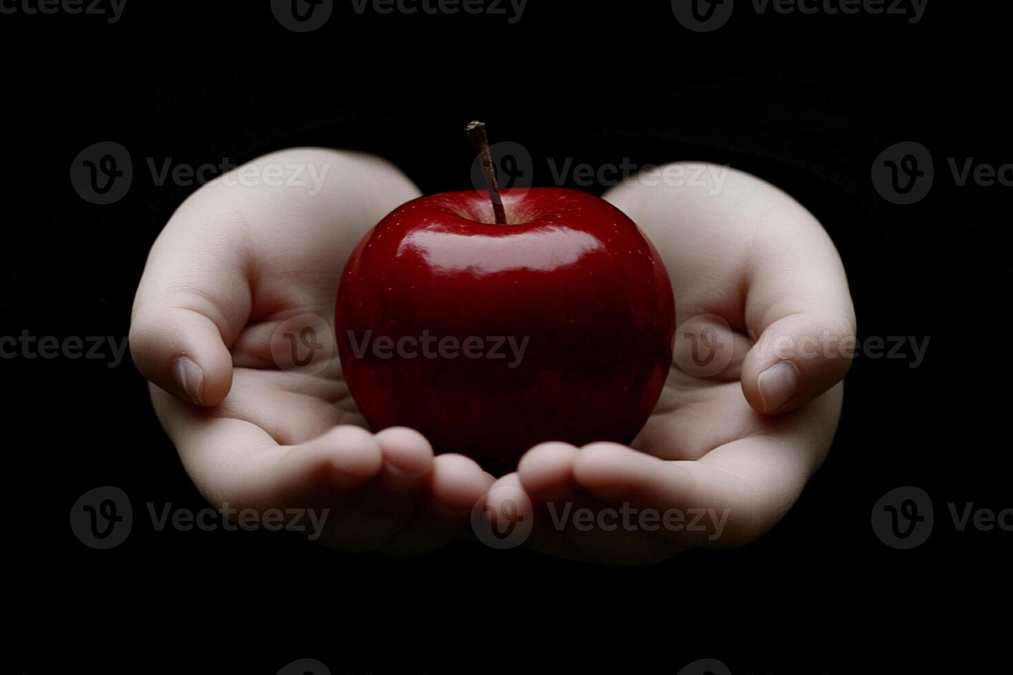 A person holding a red apple in their hands photo