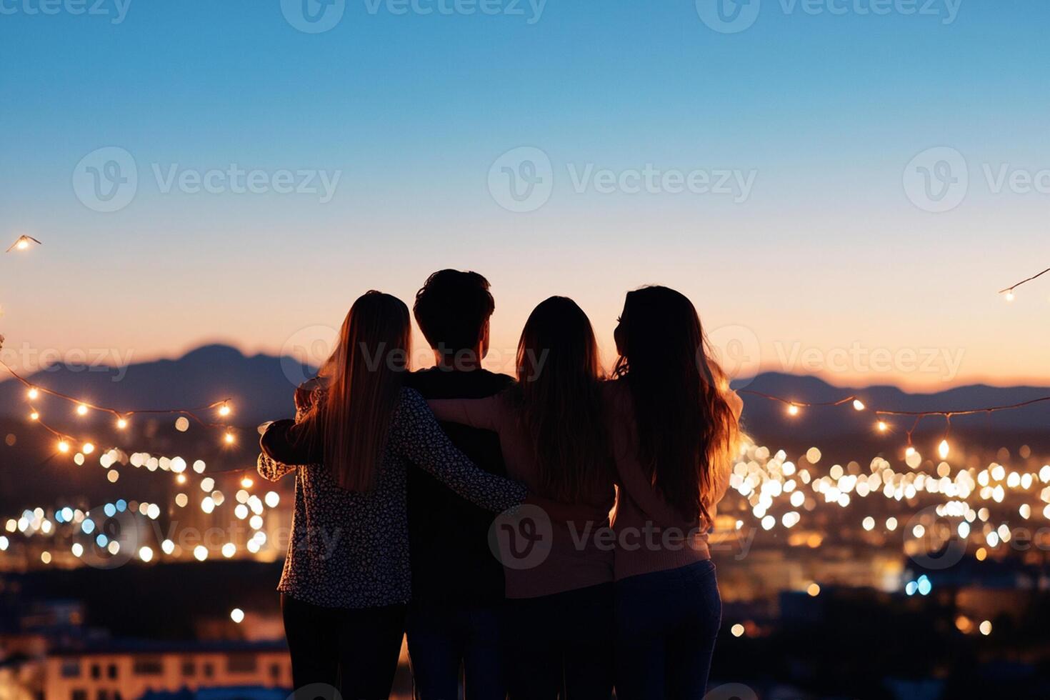 Three friends standing on a rooftop looking at the city at night photo