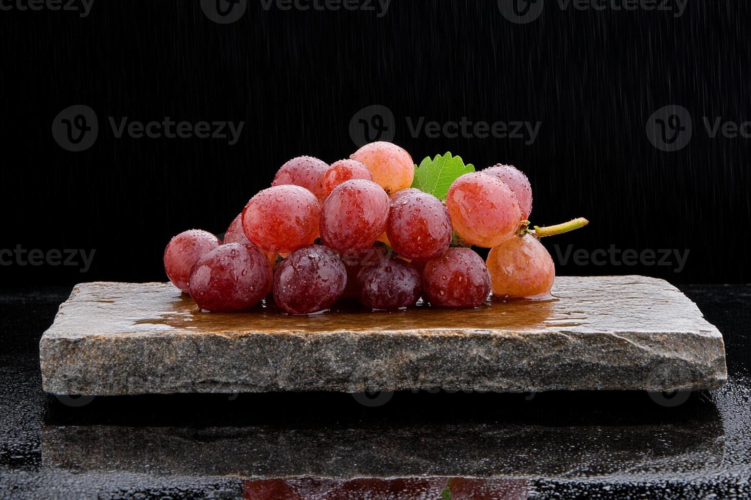 A bunch of grapes sitting on a stone slab photo