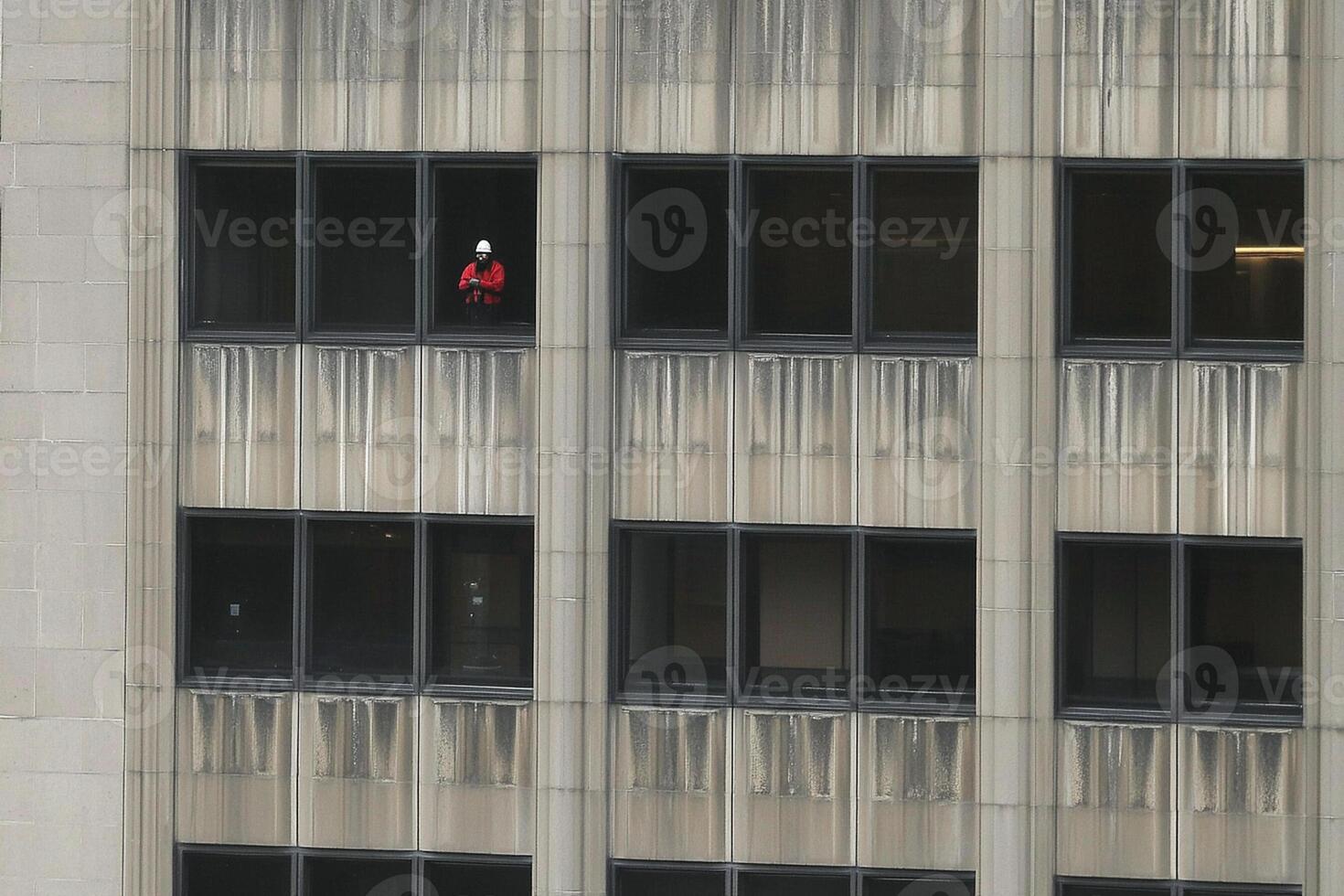 A man is seen on the ledge of a building photo