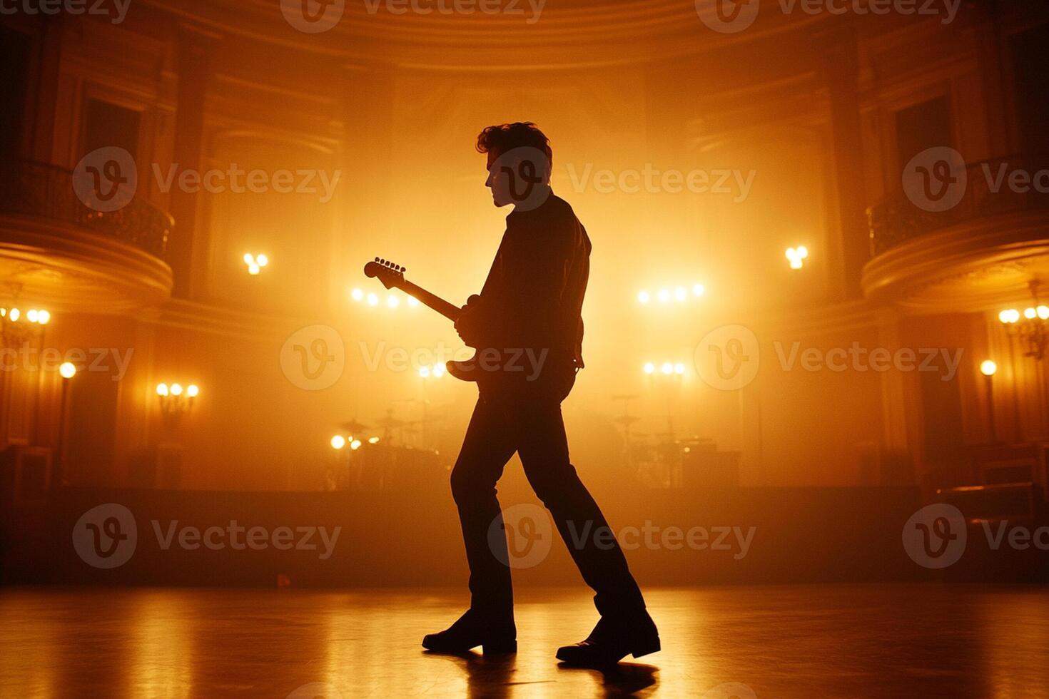 A man in silhouette playing an electric guitar in an empty room photo
